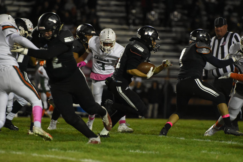Westminster's Victor Lopez (center) looks for running room against Adams City during the Wolves' homecoming game at Memorial Stadium Oct. 15. The Wolves defeated the Eagles 34-20.